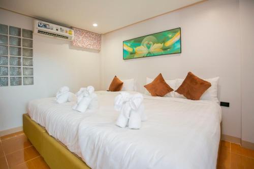 a bedroom with two beds with white towels on them at Ratana Boutique Resort - Mae Phim in Ban Ang