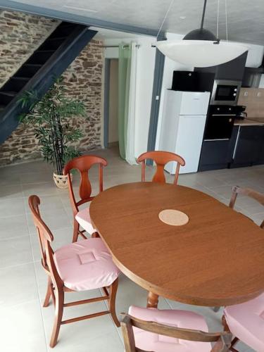 - une table et des chaises en bois dans la cuisine dans l'établissement Gite 6 personnes à Alrance, à Alrance