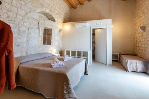 a bedroom with two beds in a stone building at Case Mediterranee in Modica