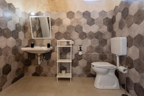a bathroom with a toilet and a sink at Case Mediterranee in Modica