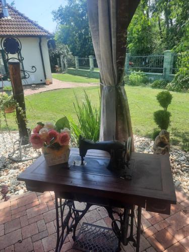 a table with a statue of a cat and flowers on it at Bačalandia- relax na samote in Veľká Dolina