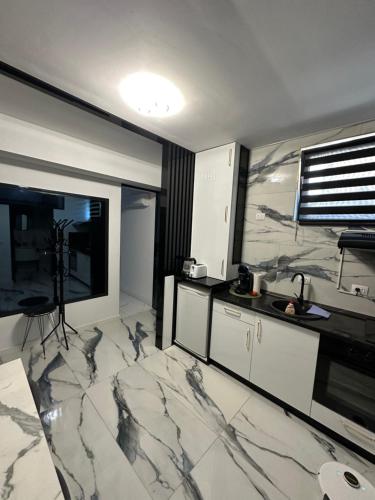 a kitchen with marble floors and a large window at Garsoniera Zona Stadion in Craiova