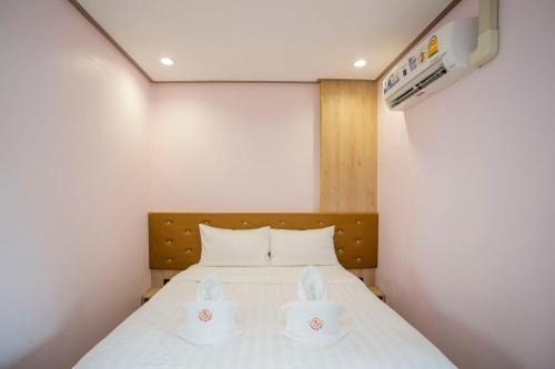 a bedroom with a bed with two white dishes on it at Ratana Boutique Resort - Mae Phim in Ban Ang