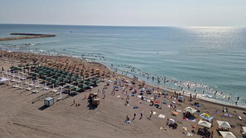 a crowd of people on a beach near the water at Hotel Cometa in Jupiter