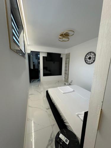 a room with a bed and a clock on the wall at Garsoniera Zona Stadion in Craiova