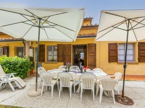 una mesa con sillas blancas y una sombrilla en Holiday Home Bellavista-3 by Interhome, en Castellina Marittima