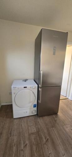 a refrigerator and a washing machine in a room at Eastpark 5 bdrms Walk to O2 Apollo and City in Manchester