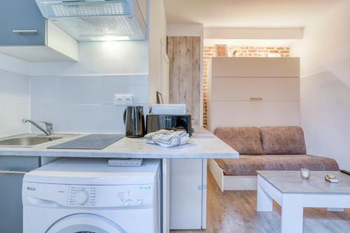 une cuisine avec un lave-linge et un sèche-linge sur un comptoir dans l'établissement Le studio Duret II, à Paris