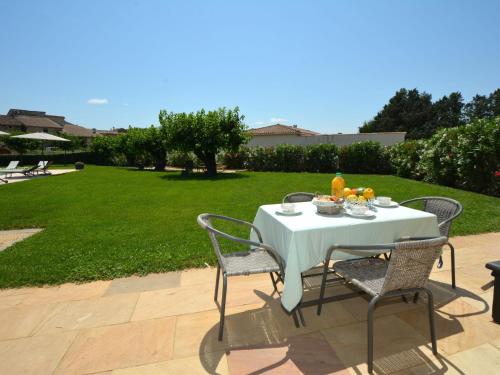 - une table blanche avec des chaises et des fruits dans l'établissement Apartment Le Mas des Trois Anges-3 by Interhome, à Saint-Denis