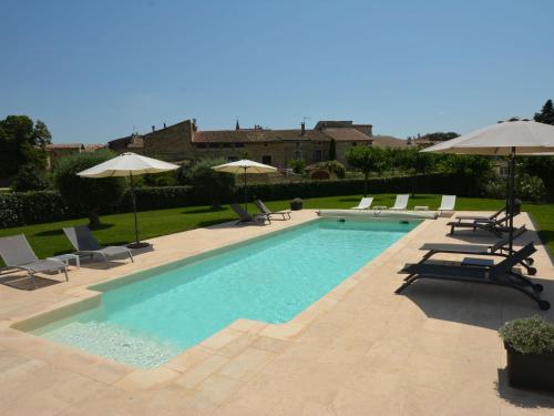 une piscine avec chaises et parasols dans l'établissement Apartment Le Mas des Trois Anges-3 by Interhome, à Saint-Denis