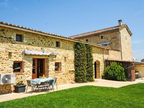 une maison en pierre avec une table et des chaises dans une cour dans l'établissement Apartment Le Mas des Trois Anges-3 by Interhome, à Saint-Denis