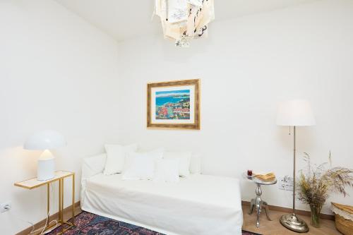 a white bedroom with a bed and a picture on the wall at Hedera Estate Hedera A8 in Dubrovnik