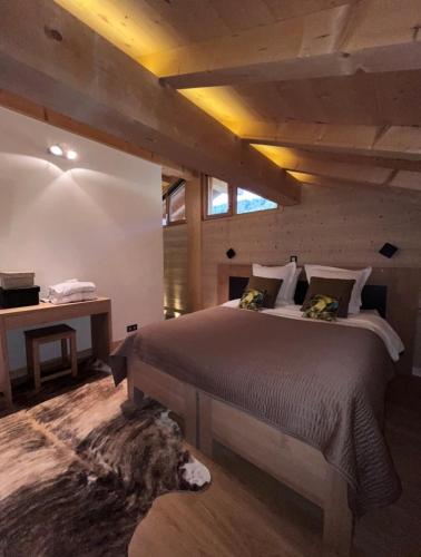une chambre avec un grand lit et un bureau dans l'établissement Chalet Inarpa - Appartements et Suites, à La Clusaz