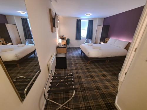 a hotel room with two beds and a staircase at Britannia Edinburgh Hotel in Edinburgh