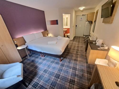 a hotel room with a bed and a bathroom at Britannia Edinburgh Hotel in Edinburgh