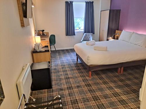 a hotel room with a bed and a television at Britannia Edinburgh Hotel in Edinburgh