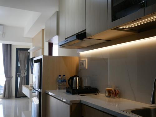 a kitchen with white cabinets and a counter top at Meisterstadt Pollux Habibie in Batam Center
