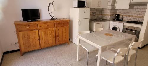 une petite cuisine avec une table et un réfrigérateur dans l'établissement Superb T2 near the beach of Port-la-Nouvelle, à Port-la-Nouvelle