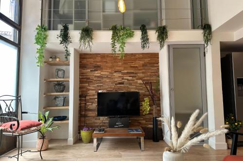- un salon avec une télévision et un mur en briques dans l'établissement Spacious duplex near the city center of Cannes, à Cannes