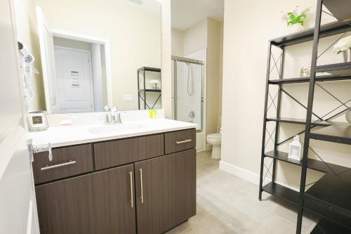a bathroom with a sink and a mirror at 216 Oasis Magic 4BD Villa 5 Min to Disney Magic in Loughman
