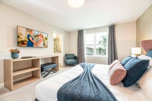 a bedroom with a bed and a desk with a television at 7992 Charming Disney Vacation Home - 5 Bd in Orlando