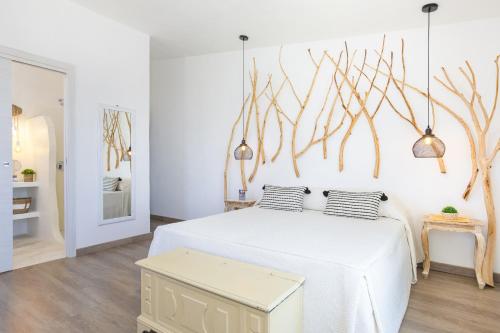 a bedroom with a white bed with two pillows at Hotel Ristorante S'Astore in Benetutti