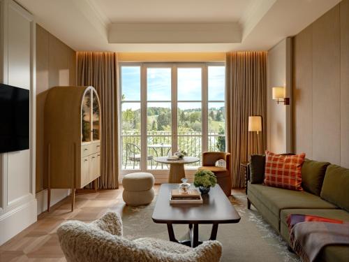 a living room with a couch and a table at Rosewood Schloss Fuschl in Hof bei Salzburg