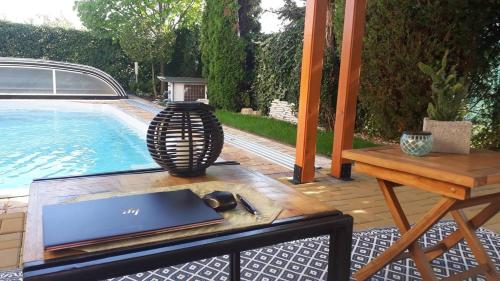 a laptop on a table next to a pool at Canadian style house with 3D effect pool in Vinosady