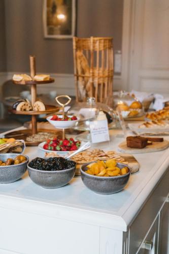 a buffet of food on a counter with bowls of food at Chateau du Clos de la Ribaudiere - Teritoria in Chasseneuil-du-Poitou