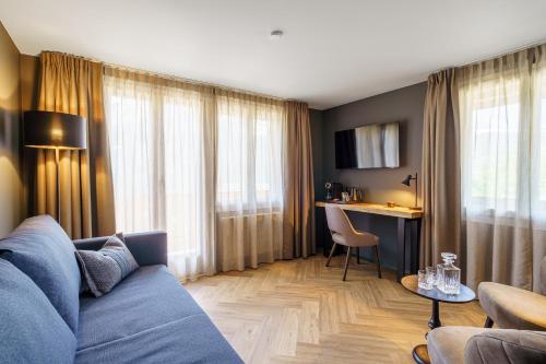 a living room with a blue couch and a table at Boutique Hotel Panorama Grindelwald in Grindelwald