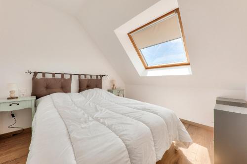 une chambre blanche avec un lit et une fenêtre dans l'établissement 1km de la plage, maison neuve avec jardin pour 4, à Sarzeau
