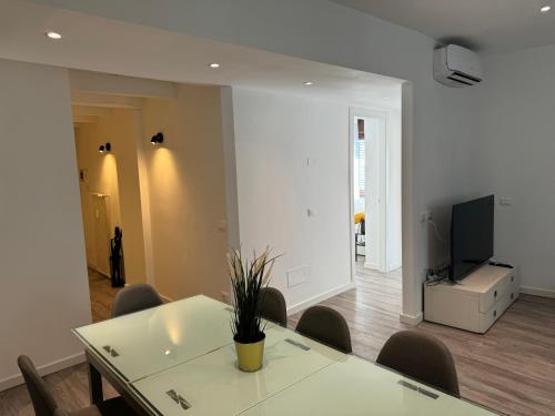 a dining room with a table and chairs and a television at FEEL - Casa Centrale Bergamo in Bergamo