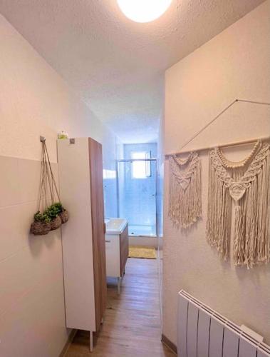 Il comprend une cuisine équipée d'un réfrigérateur blanc et une salle de bains. dans l'établissement Saint Maurice -T2 accès privé mer YourHostHelper, à Palavas-les-Flots