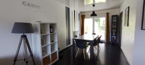 une chambre avec une table, des chaises et une lampe dans l'établissement Les Aubépines, à Rancennes