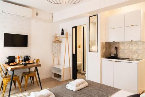 une cuisine et une salle à manger avec une table et des chaises dans l'établissement Elégant studio DIVINE SUN quartier Canal St Martin, à Paris