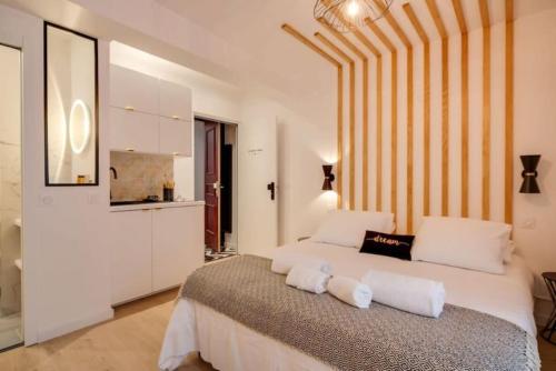 - une chambre avec un grand lit et 2 oreillers blancs dans l'établissement Elégant studio DIVINE SUN quartier Canal St Martin, à Paris