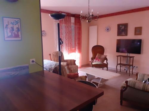 un salon avec une table et des chaises dans l'établissement Amédée vue lac, à Évian-les-Bains