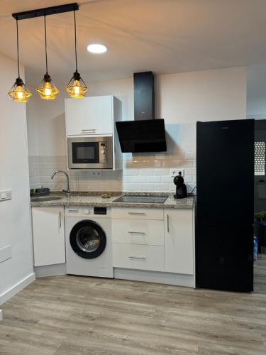 a kitchen with a washing machine and a microwave at Linerlife in Málaga