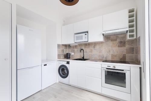 une cuisine blanche avec un évier et un lave-vaisselle dans l'établissement La Terrasse de l'Eglise, Paris Center & Eurostar 15 mn, Brand new duplex with terrasse, balcony, 2 bathrooms, parking,, à Saint-Denis