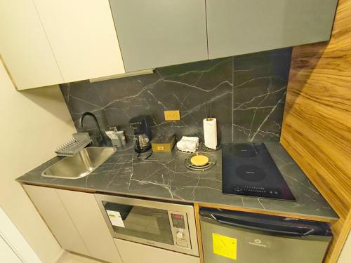 a kitchen counter with a sink and a microwave at Republica del Salvador Coliving Ecuador XOE in Quito