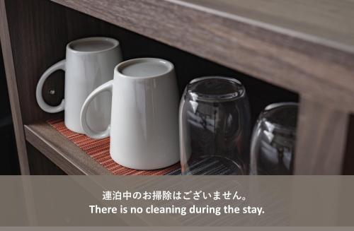 three coffee mugs and a wine glass on a shelf at Elite Inn Kyoto Station エリートイン京都駅 in Kyoto