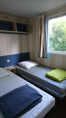 deux lits dans une chambre avec une fenêtre dans l'établissement 45mn de Paris-Mobilhome pour familles et travail-B57, à Saint-Chéron