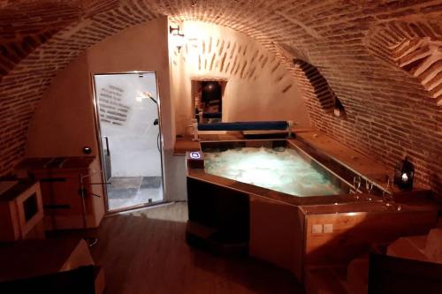 a hot tub in a room with a brick wall at Studio et spa privatif Le Puits de la Grâce in Albi