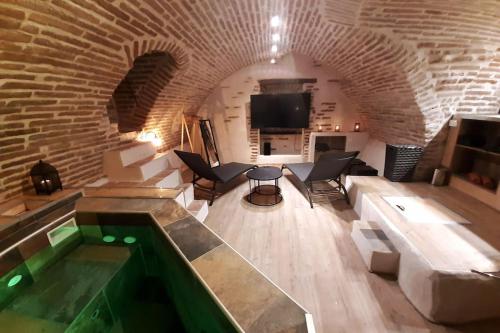 a living room with a pool in a brick wall at Studio et spa privatif Le Puits de la Grâce in Albi
