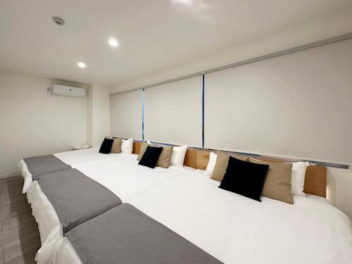 ŌsukachōにあるbHOTEL Nikke - Apt for 10Ppl Ideal for Big Group in City Centerの枕付きの大きな白いベッドが2つある部屋
