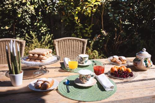 a wooden table with breakfast foods and drinks on it at Hotel Ristorante S'Astore in Benetutti