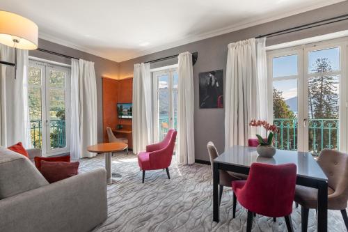 a living room with a couch and a table and chairs at Impérial Palace in Annecy