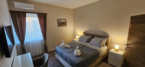 a bedroom with a bed with two swans on it at Oliane Rooms & Accommodation in Bribir