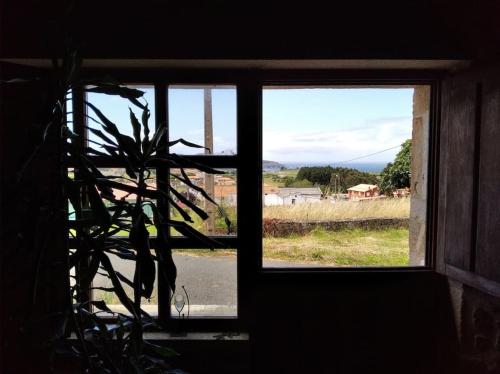a window in a building with a view of a field at Casa do Souto in Ferrol