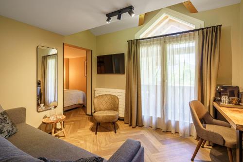 a living room with a couch and a window at Boutique Hotel Panorama Grindelwald in Grindelwald